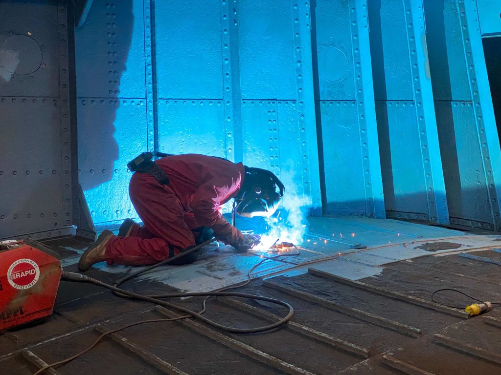 Man extracting steel from the LCT 7074 Landing Craft 1024x768 - The story behind this year's RBL Masterpiece Poppy Coin