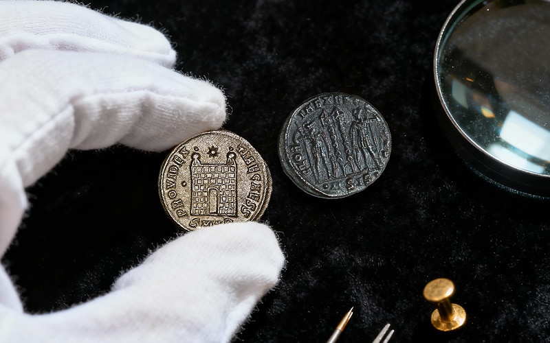 roman coins in hand - Britain’s Biggest Roman Coin Hoard? 🪙